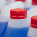 Blue Windshield washer fluid, Professional Refill Blue color, chemicals in plastic bottles cans in the warehouse store. Antibacterial Liquid Wash in plastic canisters with red plastic cork cap.